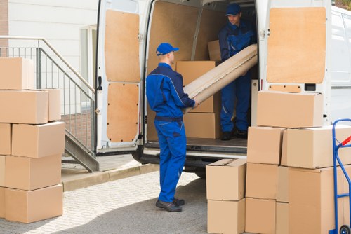 Man with a van loading furniture for a move in West Kensington