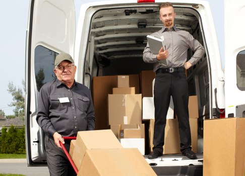 Mover carrying boxes safely during a West Kensington man with van service
