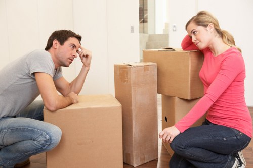 Removal team transporting boxes and furniture from a flat in West Kensington