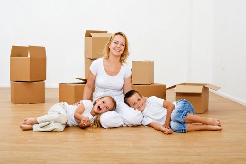 Removalists carrying furniture down stairs in a West Kensington property